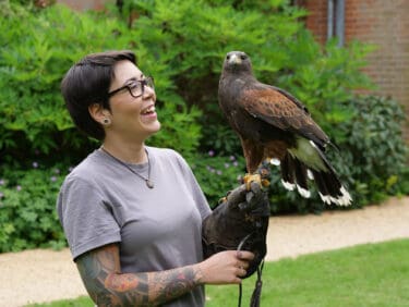 Capel Manor College animal management student holding a bird during a practical session
