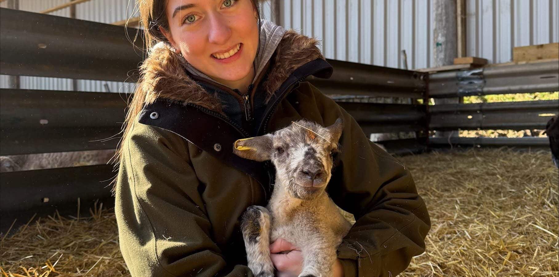 Agriculture student holding a lamb