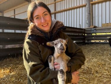 Agriculture student holding a lamb