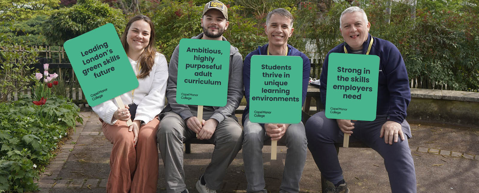 People sitting on a bench with placards