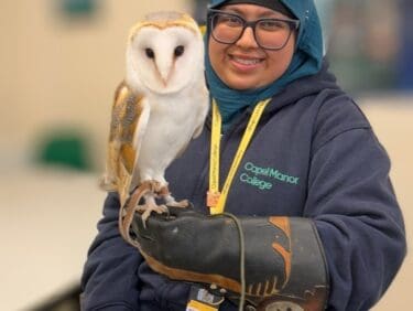 Capel Manor College animal management student, Aisha, holding an owl.
