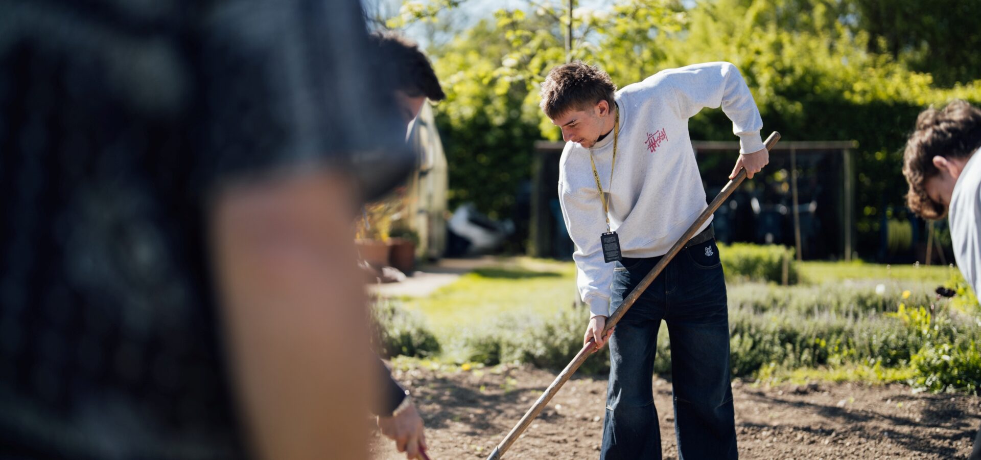 Horticulture student at Capel Manor College raking soil.
