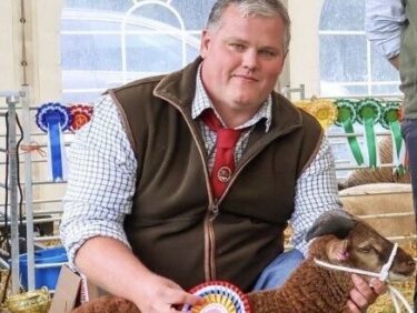 Mark Ballard, agriculture tutor at Capel Manor College, showing a sheep with a rosette.