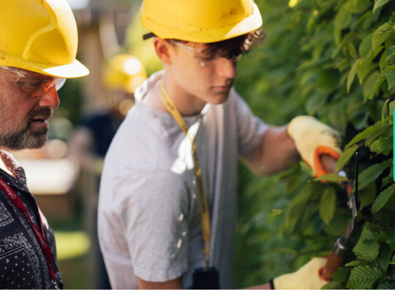 A horticulture student at Capel Manor College being observed by a tutor during a practical session.