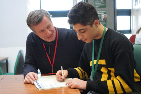 A tutor sitting down and teaching a student at Capel Manor College in London. An example of where completing the Associate Trainer Programme could take you.