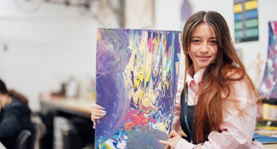 An art and design student at Capel Manor College in London, displaying their artwork.
