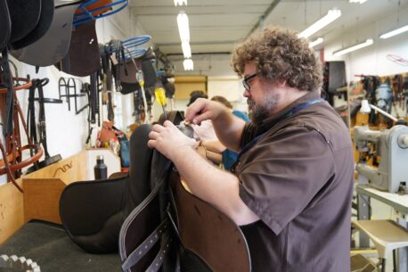 A leatherwork student at Capel Manor College in Enfield, working on a saddle.