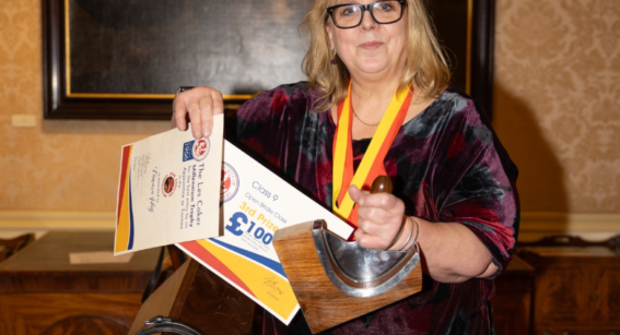 A saddlery and shoemaking (leatherwork) student from Capel Manor College in London, holding her recent award wins.